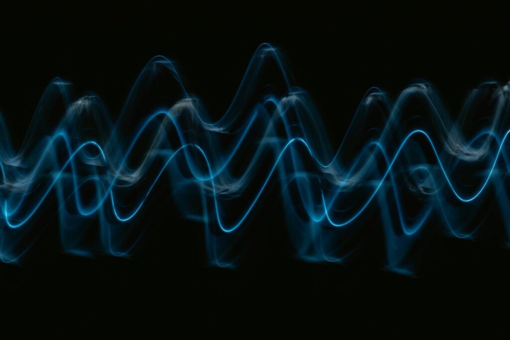 A blue light wave pattern on a black background, representing data with sound in Exploring Sonification.
