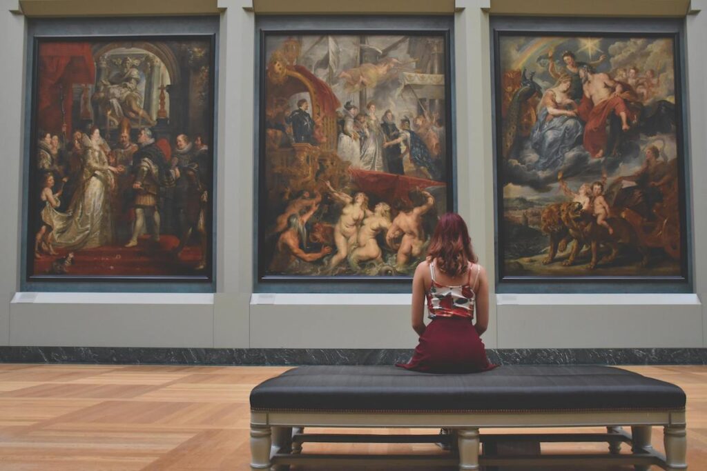 Research on Blind Adults' Museum Attitudes: Woman seated by paintings on bench.